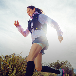 Shop trail gear. A woman runnin on a trail path