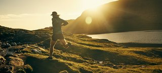Shot of a young man out running on a trail in the mountains
